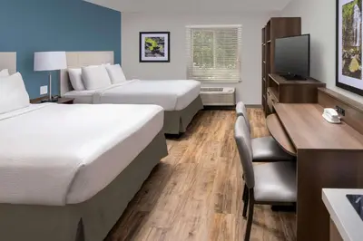 a hotel room with two beds and a desk at Woodspring Suites Cherry Hill in Cherry Hill