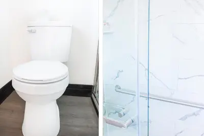 a bathroom with a toilet and a glass shower at The Lancaster Motel By OYO Ronks near Paradise in Ronks