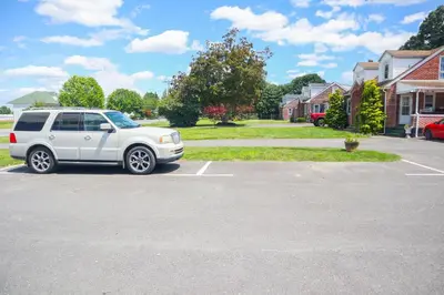 a white suv parked in a parking lot at The Lancaster Motel By OYO Ronks near Paradise in Ronks