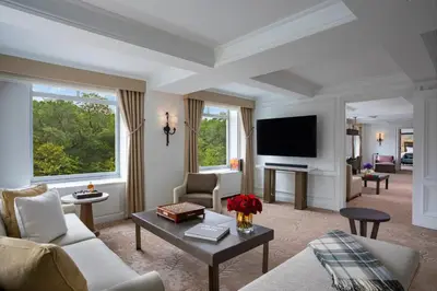 a living room with a couch and a tv at The Ritz-Carlton New York, Central Park in New York