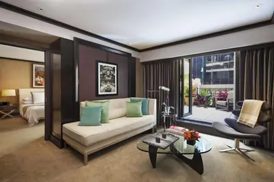 a living room with a couch and a bed and a table at The Chatwal, The Unbound Collection by Hyatt in New York