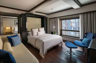 a hotel room with a bed and a couch at The Chatwal, The Unbound Collection by Hyatt in New York