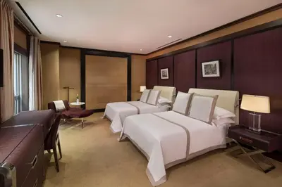 a hotel room with three beds and a couch at The Chatwal, The Unbound Collection by Hyatt in New York