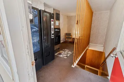 a hallway with a black door and a staircase at Buena Vista Inn Motel in Delhi