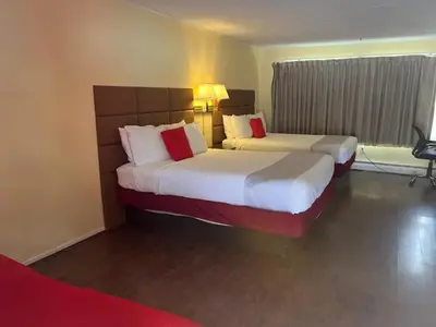 a hotel room with two beds and a window at Buena Vista Inn Motel in Delhi