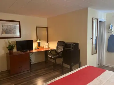 a bedroom with a desk with a computer and a chair at Buena Vista Inn Motel in Delhi