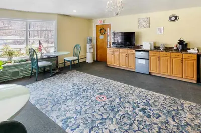 a kitchen with a table and a kitchen with a table and chairs at Buena Vista Inn Motel in Delhi