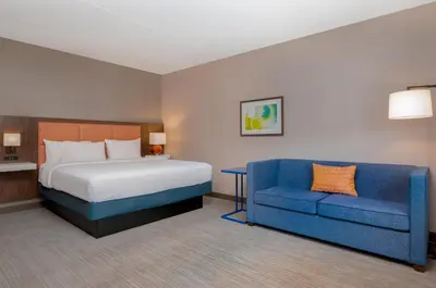 a bedroom with a bed and a blue couch at Hampton Inn & Suites Wilkes-Barre in Wilkes-Barre
