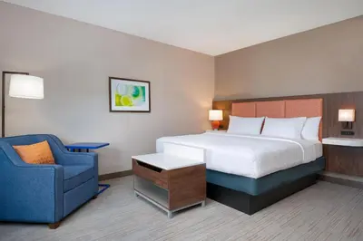 a hotel room with a bed and a blue chair at Hampton Inn & Suites Wilkes-Barre in Wilkes-Barre