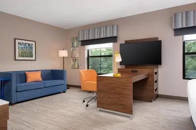 a living room with a blue couch and a tv at Hampton Inn & Suites Wilkes-Barre in Wilkes-Barre