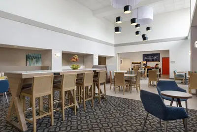 a dining room with tables and chairs and a cafeteria at Hampton Inn & Suites Wilkes-Barre in Wilkes-Barre