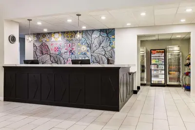 a restaurant with a counter with a colorful wall at La Quinta by Wyndham Mt. Laurel - Philadelphia in Mount Laurel