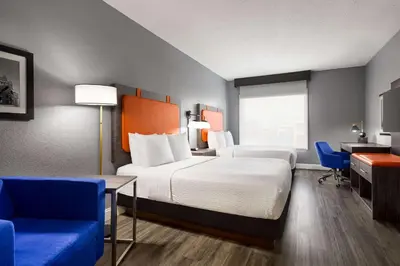 a hotel room with a bed and a desk and chairs at La Quinta by Wyndham Mt. Laurel - Philadelphia in Mount Laurel