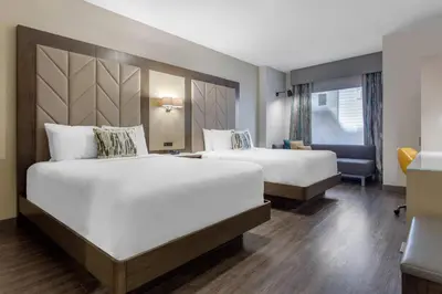 a hotel room with two beds and a desk at Cambria Hotel Philadelphia Downtown - Center City in Philadelphia