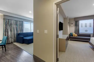 a living room with a blue couch and a living room at Cambria Hotel Philadelphia Downtown - Center City in Philadelphia