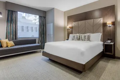 a bedroom with a large bed and a couch at Cambria Hotel Philadelphia Downtown - Center City in Philadelphia