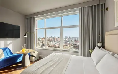 a hotel room with a bed and a large window at ModernHaus SoHo in New York