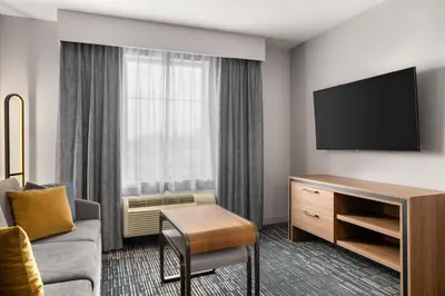 a hotel room with a couch and a tv at Homewood Suites by Hilton Newtown - Langhorne, PA in Newtown