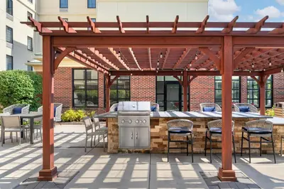 a wooden pergola with a grill and tables and chairs at Homewood Suites by Hilton Newtown - Langhorne, PA in Newtown