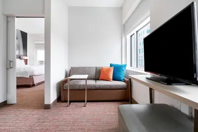 a living room with a tv and a couch and a bedroom at Residence Inn by Marriott Wilmington Downtown in Wilmington