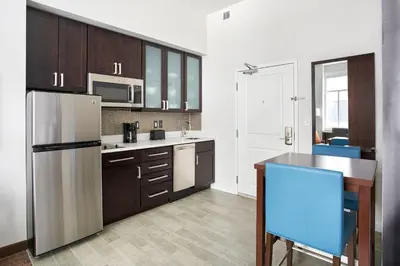 a kitchen with brown cabinets and a refrigerator at Residence Inn by Marriott Wilmington Downtown in Wilmington