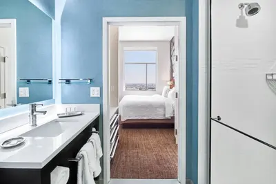 a bathroom with a sink and a bedroom with a bed at Residence Inn by Marriott Wilmington Downtown in Wilmington