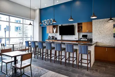 a kitchen with a bar with blue walls at Residence Inn by Marriott Wilmington Downtown in Wilmington