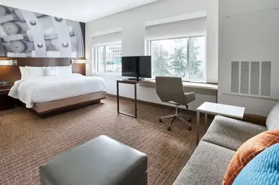 a hotel room with a bed and a couch at Residence Inn by Marriott Wilmington Downtown in Wilmington