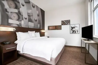 a bedroom with a large bed and a television at Residence Inn by Marriott Wilmington Downtown in Wilmington