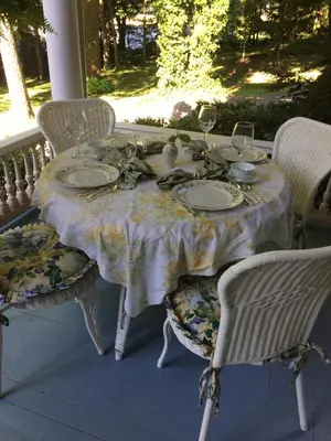 a table with plates and wine glasses on a porch at Susquehanna Manor Inn in Marietta