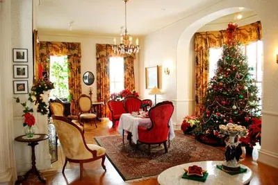 a living room with a christmas tree and red chairs at Susquehanna Manor Inn in Marietta