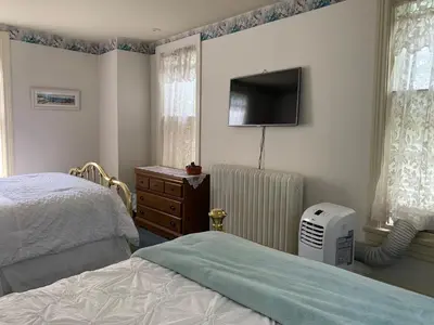 a bedroom with a bed and a flat screen tv at Susquehanna Manor Inn in Marietta