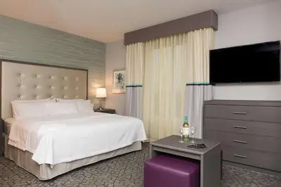 a hotel room with a bed and a flat screen tv at Homewood Suites By Hilton Allentown Bethlehem Center Valley in Center Valley