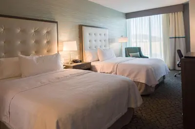 a hotel room with two beds and a chair at Homewood Suites By Hilton Allentown Bethlehem Center Valley in Center Valley