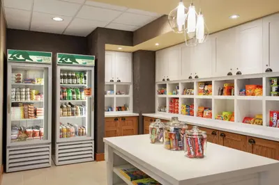 a kitchen with two refrigerators and a counter with food at Homewood Suites by Hilton Allentown-West/Fogelsville in Fogelsville