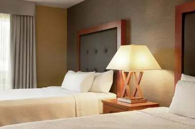 a hotel room with two beds and a lamp at Homewood Suites by Hilton Allentown-West/Fogelsville in Fogelsville