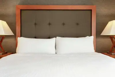 a large bed with white pillows and two lamps at Homewood Suites by Hilton Allentown-West/Fogelsville in Fogelsville