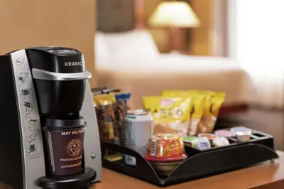 a coffee maker sitting on a table with a tray of food at Homewood Suites by Hilton Allentown-West/Fogelsville in Fogelsville