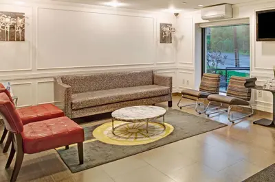 a living room with a couch and chairs at Ramada by Wyndham Staten Island in Staten Island