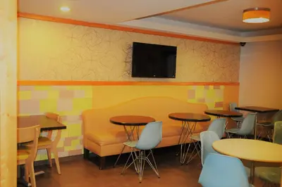 a restaurant with tables and chairs and a tv on the wall at Ramada by Wyndham Staten Island in Staten Island