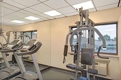 a gym with several tread machines in a row at Ramada by Wyndham Staten Island in Staten Island