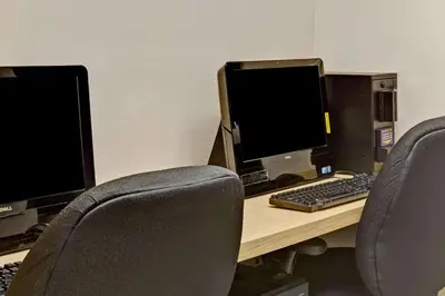 two computer monitors sitting on top of a desk at Ramada by Wyndham Staten Island in Staten Island