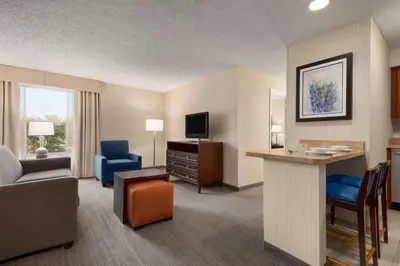 a hotel room with a king bed and a living room at Homewood Suites by Hilton Wilmington-Brandywine Valley in Talleyville