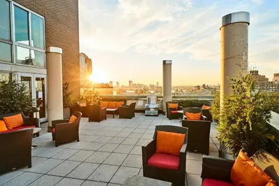 a rooftop patio with chairs and a grill on a building at Sheraton Tribeca New York Hotel in New York