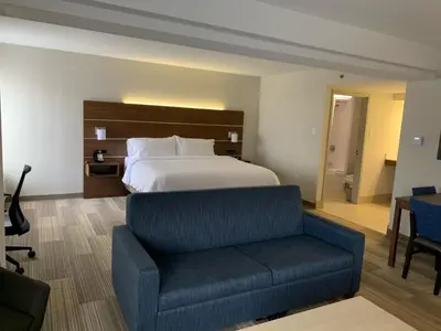 a hotel room with a bed and a couch at Holiday Inn Express Voorhees/ Mt. Laurel by IHG in Voorhees