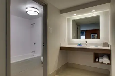 a bathroom with a sink and a tub and a mirror at Holiday Inn Express Voorhees/ Mt. Laurel by IHG in Voorhees