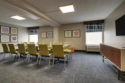 a conference room with a long table and yellow chairs at Holiday Inn Express Voorhees/ Mt. Laurel by IHG in Voorhees