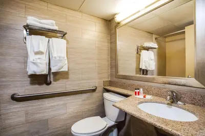 a bathroom with a toilet and a sink and a mirror at Howard Johnson by Wyndham North Plainfield in North Plainfield