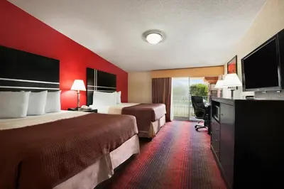 a hotel room with two beds and a balcony at Howard Johnson by Wyndham North Plainfield in North Plainfield