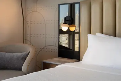 a bedroom with a bed and a mirror and a chair at Courtyard by Marriott New York Manhattan / Soho in New York